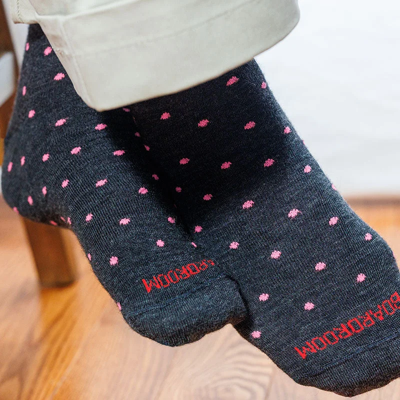 man wearing charcoal grey dress socks decorated with pink dots paired with khaki slacks